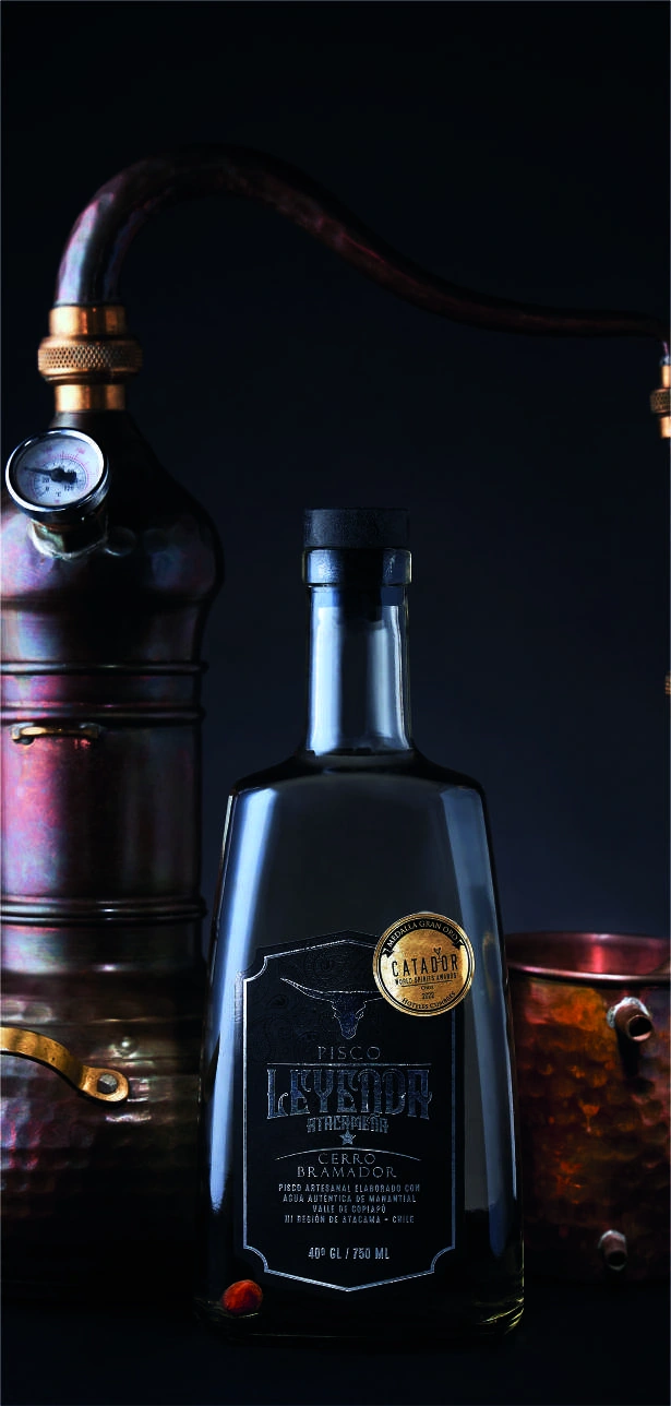 Pisco Leyenda Atacameña junto a un alambique de cobre